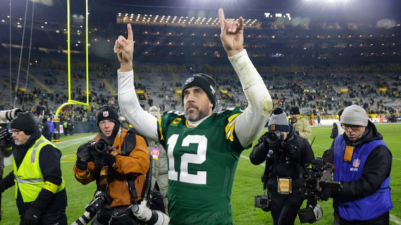 Green Bay Packers quarterback Aaron Rodgers (12) waves to fans as he leaves the field...