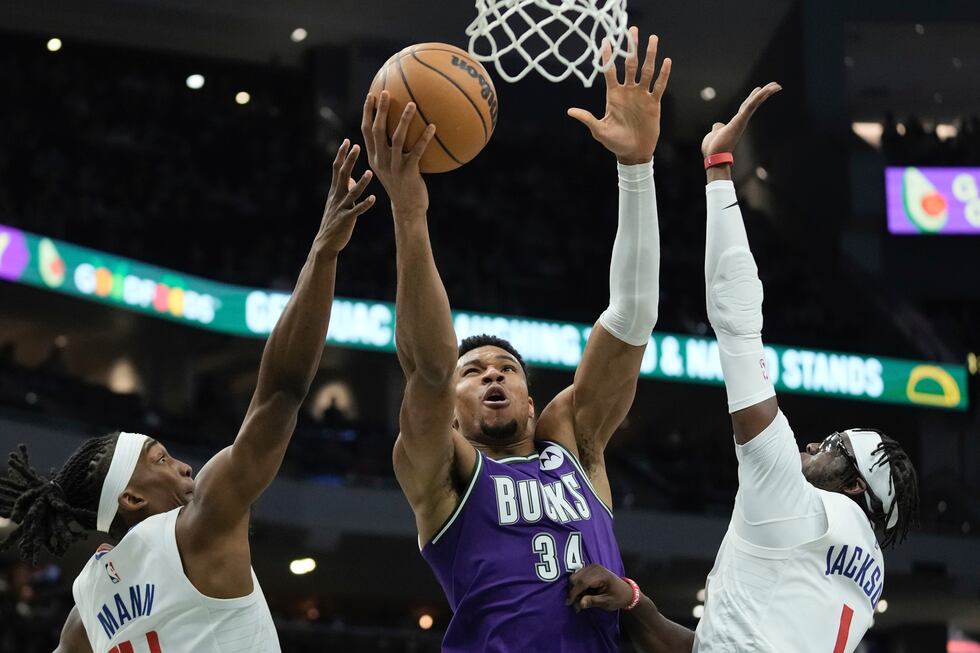 Milwaukee Bucks' Giannis Antetokounmpo shoots between Los Angeles Clippers' Terance Mann and...