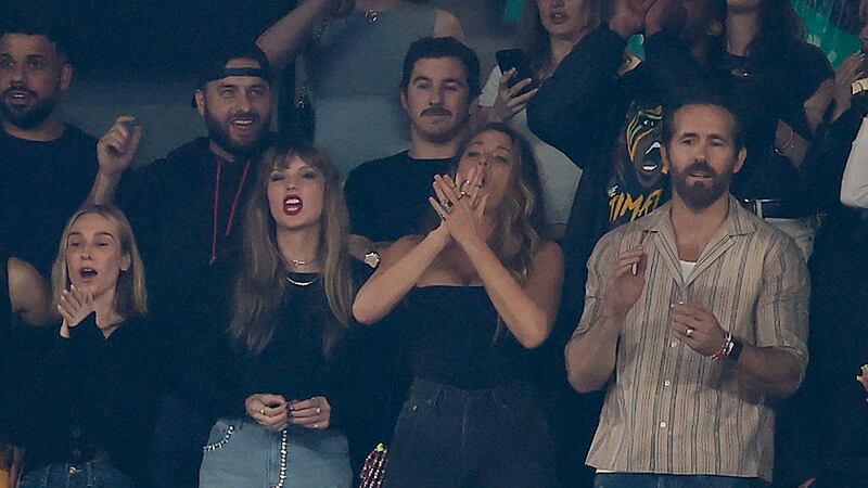 Taylor Swift, left, stands for the national anthem before the first quarter of and NFL...