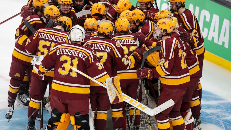 Minnesota players huddle before an NCAA men's Frozen Four semifinal hockey game against...