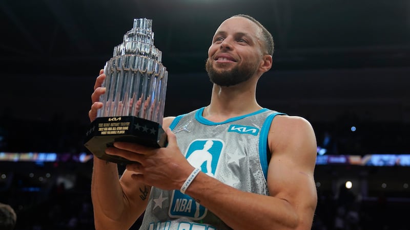 Golden State Warriors' Stephen Curry holds up the Kobe Bryant Trophy after being named the MVP...